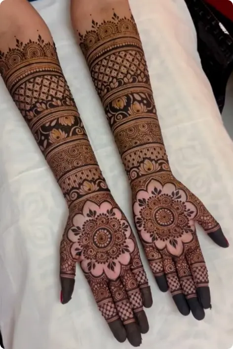 Beautiful bridal henna patterns on hands, displaying a mix of traditional and modern designs in deep brown hues.