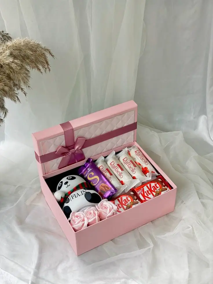 A pink gift box filled with assorted candies, chocolates, and delightful treats Handmade Gifts Hampers in Thrissur