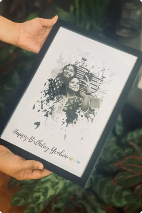 Customized black-and-white portrait frame gift featuring two friends smiling together, beautifully designed with artistic splash effects and a “Happy Birthday” message. A creative and personalized keepsake perfect for special occasions and memorable celebrations from Gifts Hampers in Thrissur.